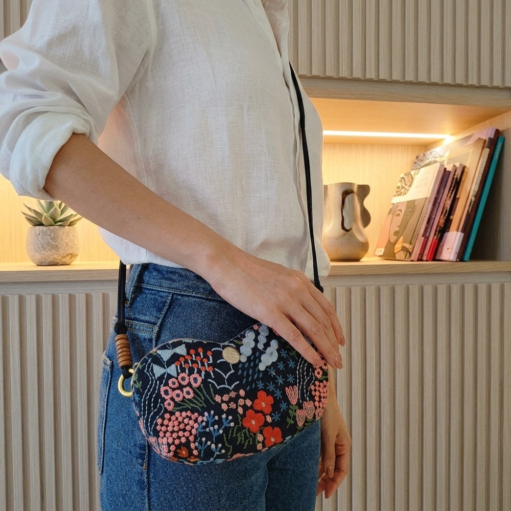 Woman wearing Bloom embroidered glasses case crossbody in Wild Garden floral — MonBebe Singapore