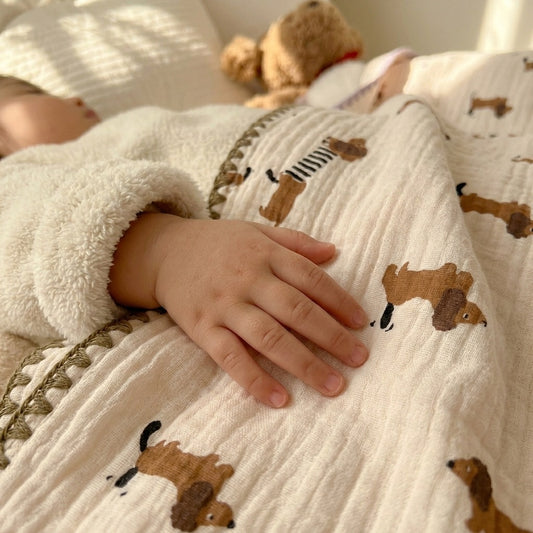 Cloud cotton muslin blanket in Frankie draped on bed — striped dachshund print, MonBebe Singapore