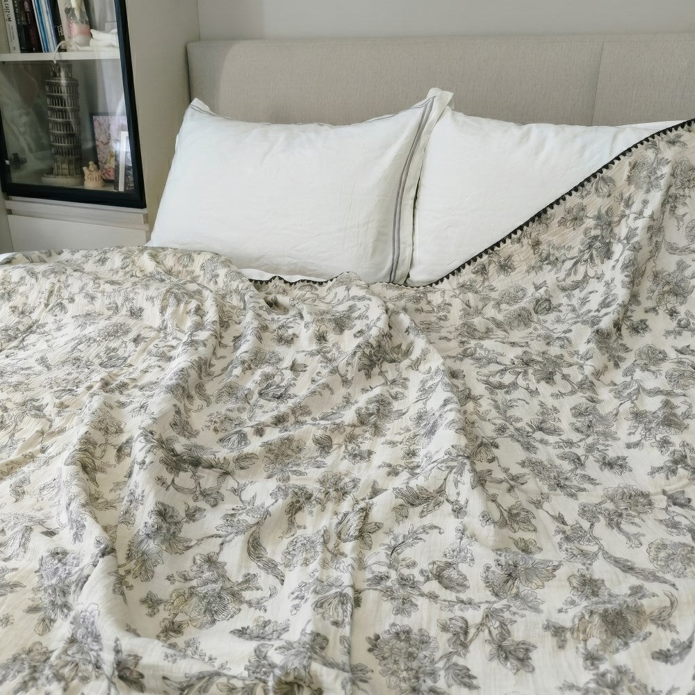 Cloud cotton muslin blanket in Secret Garden draped on bed  black botanical print —  MonBebe Singapore