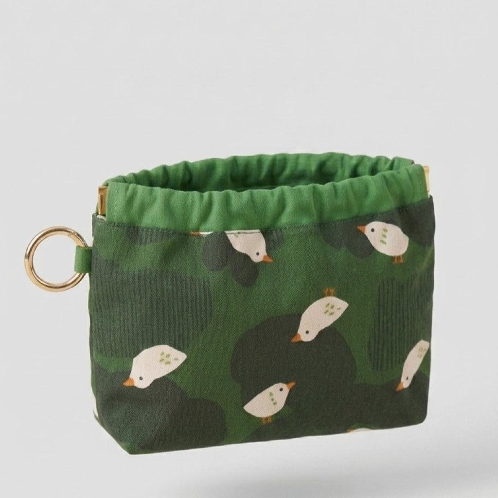 Duck Pond Travel Pouch flat lay, white duck print on green cotton-linen, MonBebe Singapore