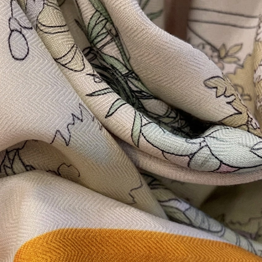 Close-up of Haru silk-wool blanket shawl showing muted botanical illustration and fabric texture detail —  MonBebe Singapore