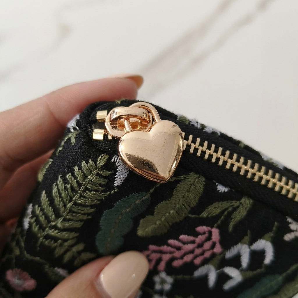 Close-up of gold heart-shaped zip pull on Briar pouch, MonBebe Singapore