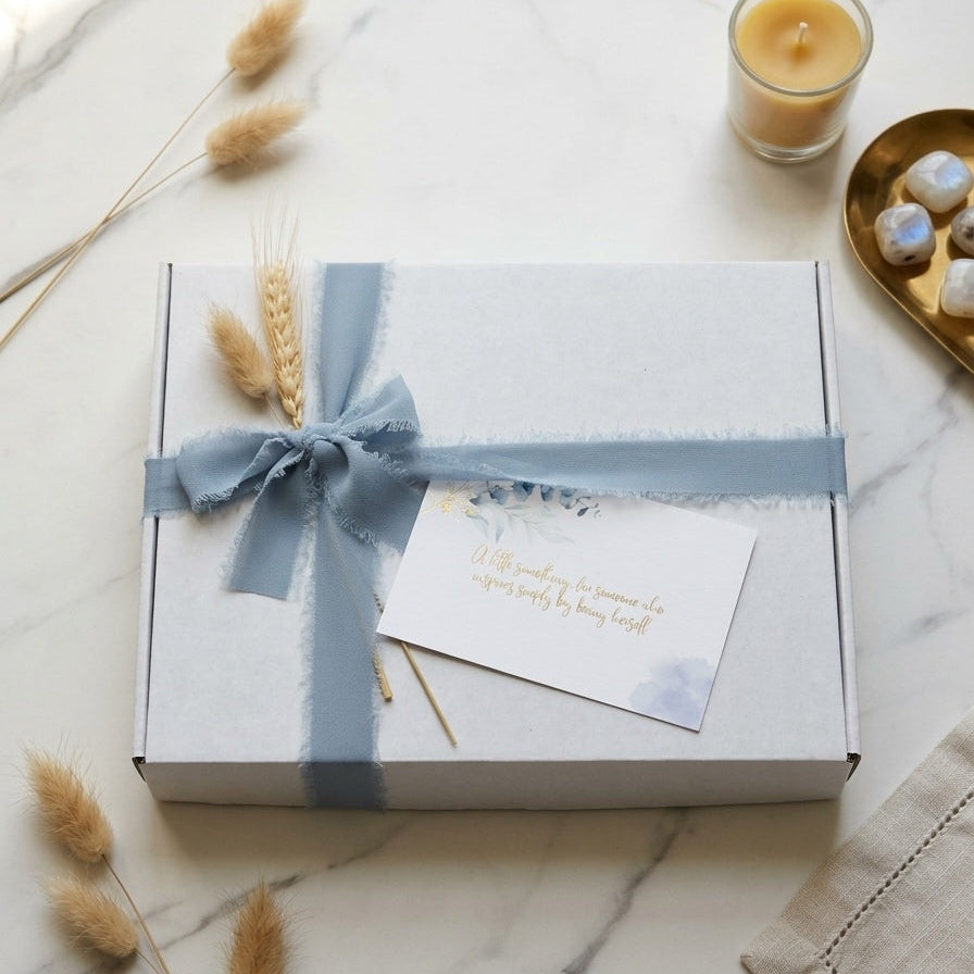 Gift box with a periwinkle ribbon on a marble surface with decorative elements —  MonBebe Singapore