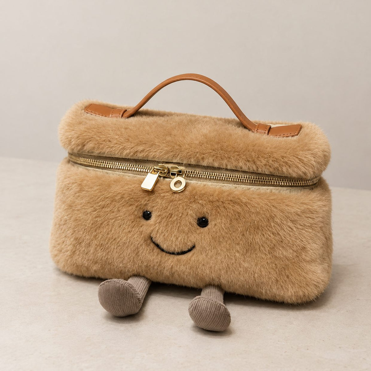 Camel furry Laura Smiley crossbody bag with gold zipper, tan leather handle, and corduroy feet