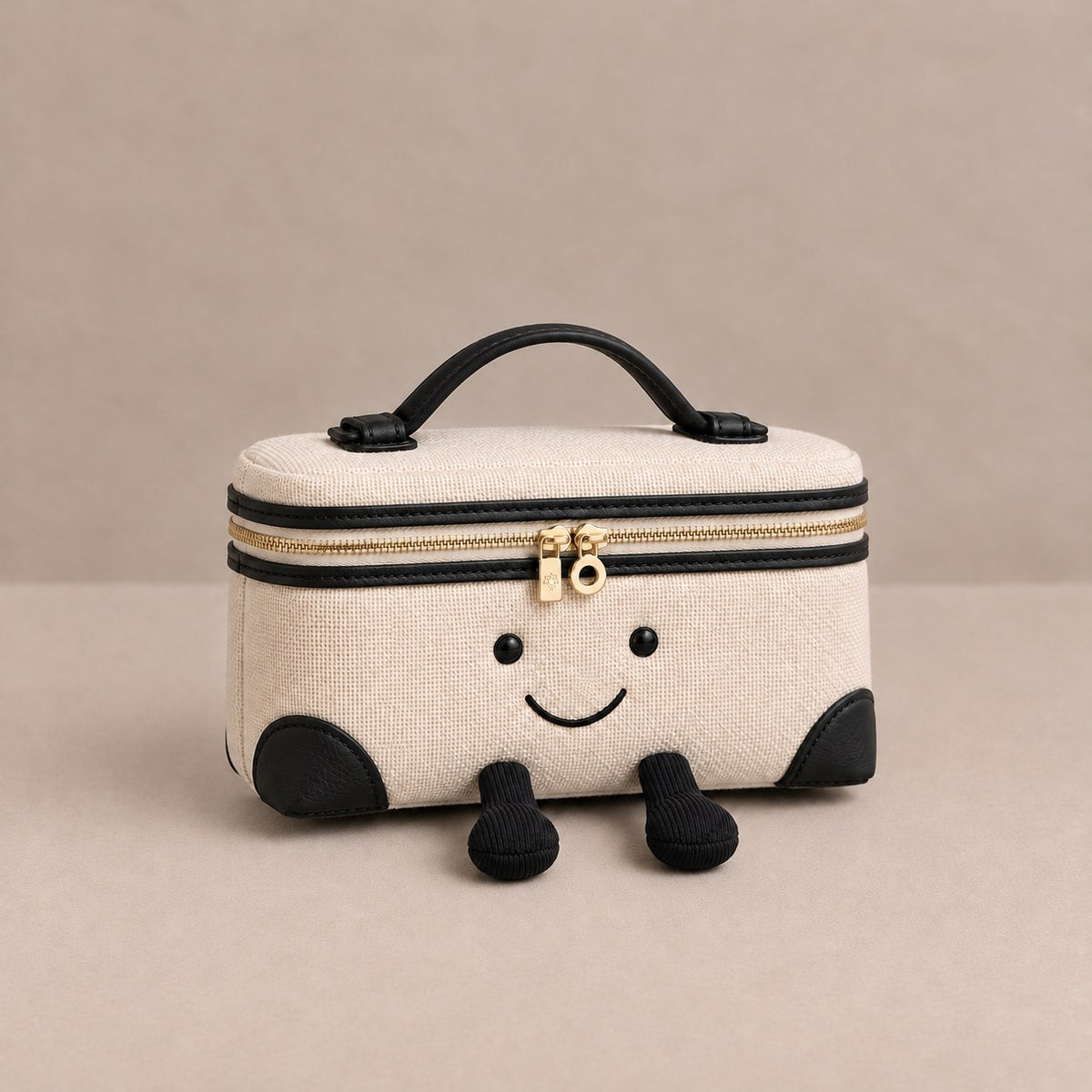 Laura Smiley crossbody bag in cream and black canvas material with gold zipper, black leather handle, and corduroy feet
