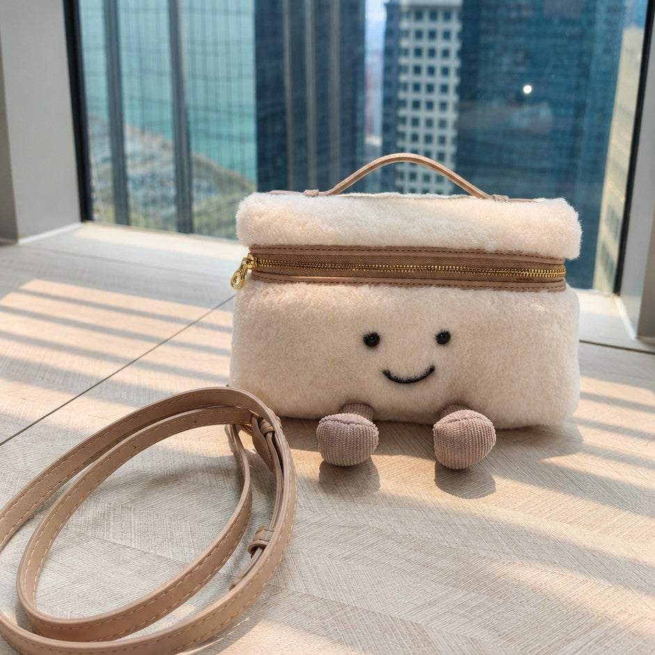 Cream furry Laura Smiley crossbody bag with gold zipper, beige leather handle, and beige crossbody strap, corduroy feet