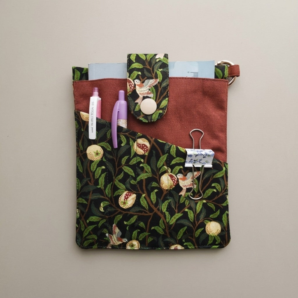 Linnet book pouch open, showing pens in the front pocket and a notebook in the main compartment, MonBebe Singapore