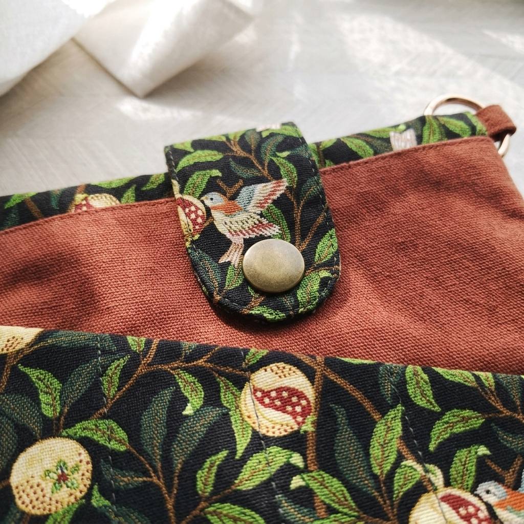 Close-up of the snap-closed phone pocket on the Linnet book pouch, MonBebe Singapore