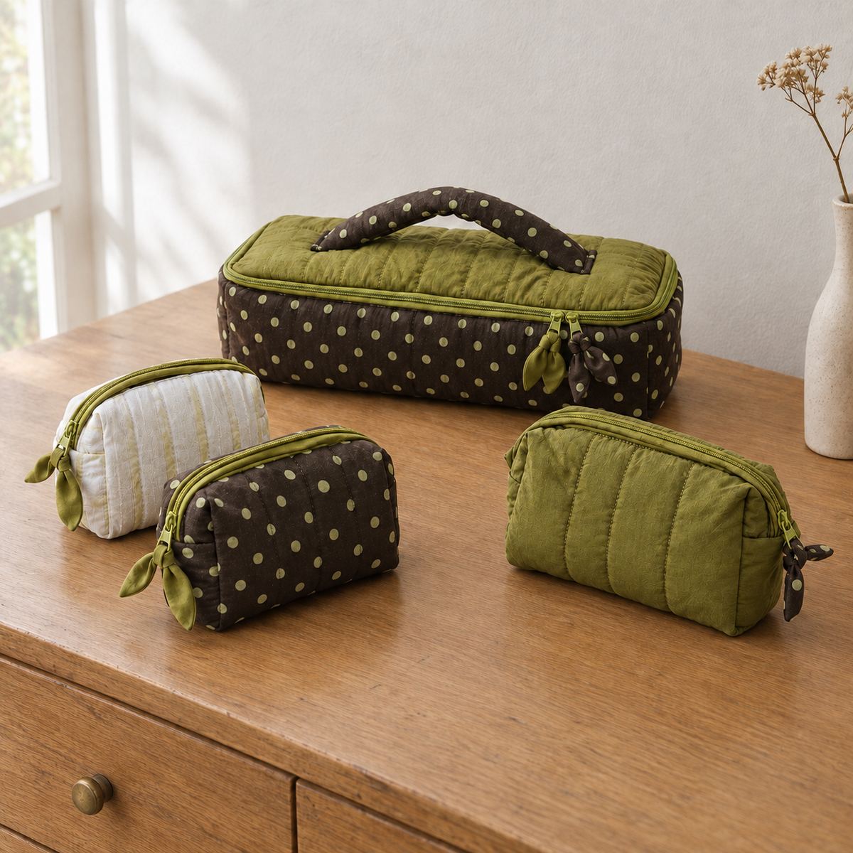 Poppy quilted travel case in polka dot, olive and pale olive stripe styled on a wooden dresser, MonBebe Singapore