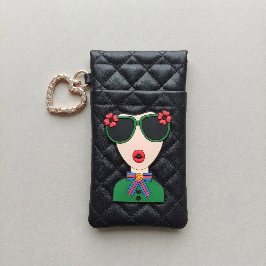 Black quilted glasses case with illustrated face patch and heart-shaped rhinestone hook