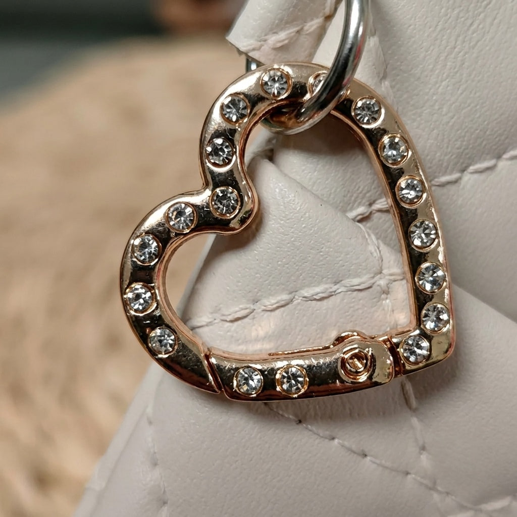 Close-up of heart-shaped rhinestone hook hardware on quilted glasses case, MonBebe