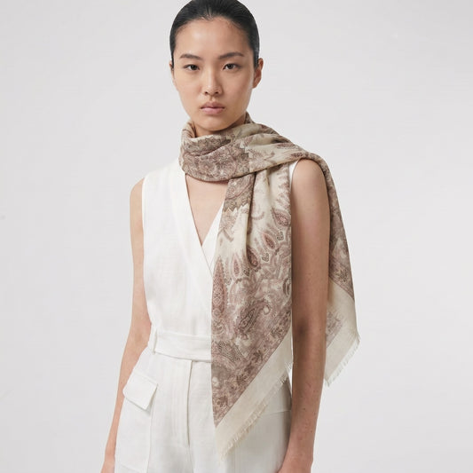 Woman wearing Sera 135cm silk-wool scarf with scattered paisley print — studio shot, MonBebe