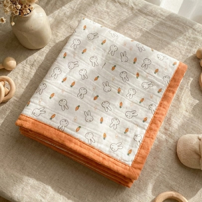 Tokki bamboo cotton blanket folded neatly showing four-layer gauze construction and bunny print, MonBebe